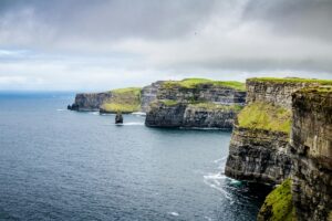 This image showcases the majestic Cliffs of Moher in Ireland, with towering rock formations rising from the churning sea below. The overcast sky and the patches of greenery on the cliffs add to the dramatic and timeless beauty of the scene. Just as these cliffs are a striking and enduring feature of Ireland&rsquo;s landscape, the &ldquo;2025 Influencer Marketing Trends in Ireland&rdquo; are set to be significant elements shaping the marketing world there. They may bring about new and bold approaches, much like how the cliffs command attention, while also incorporating the unique charm and character of Ireland, similar to the greenery that adorns the cliffs.